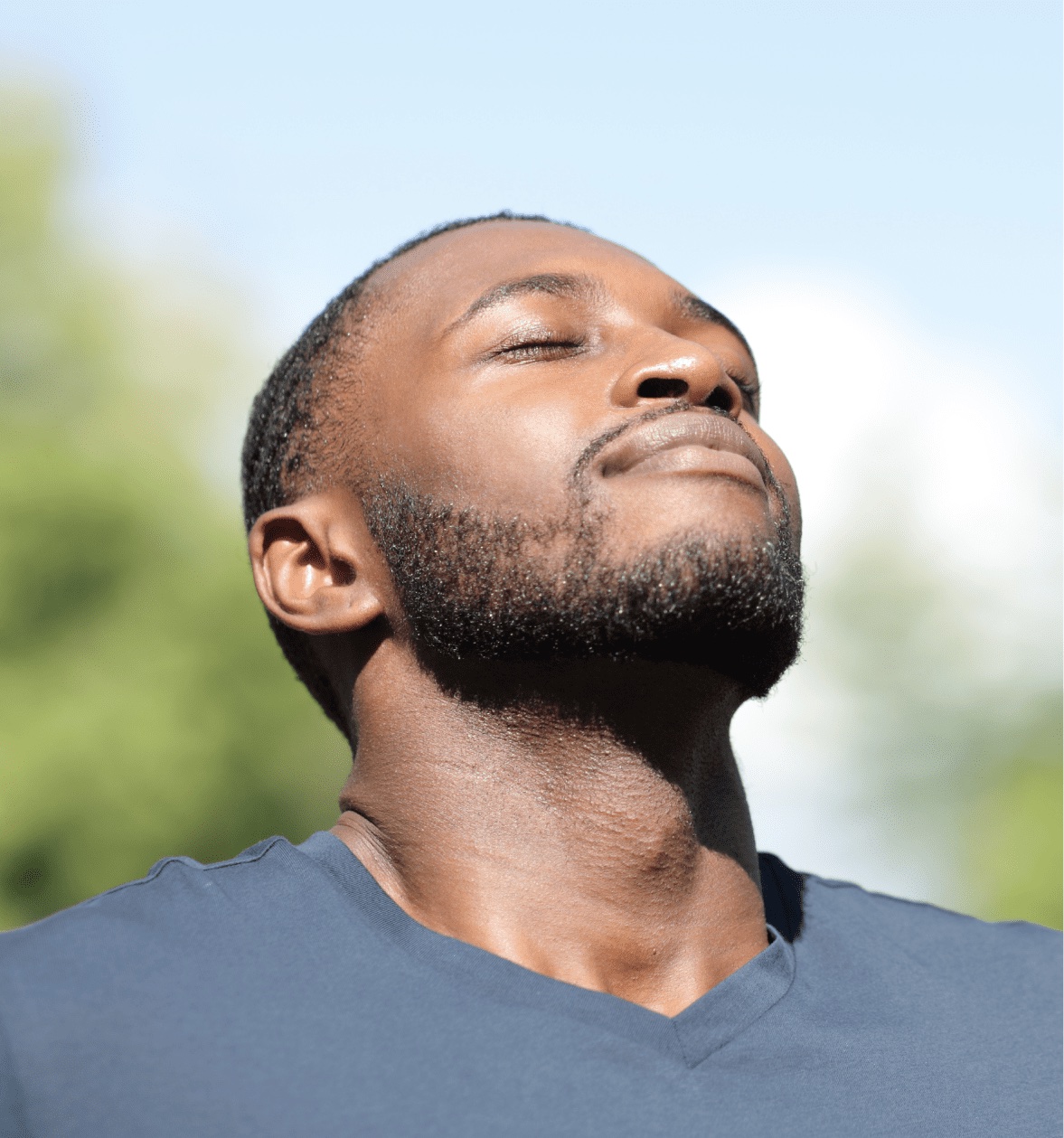 A man with his eyes closed, face turned to the sun